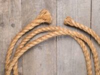 Faxco natural 10ft cotton rope on wooden table, showcasing soft texture and triple-strand weave