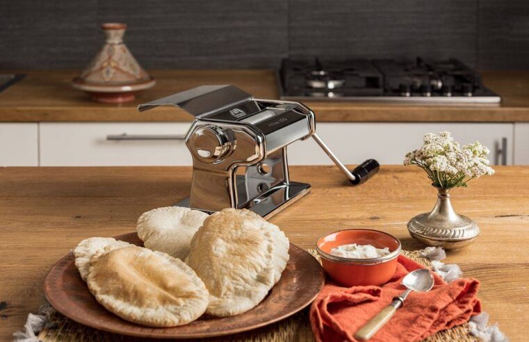 Marcato Atlasmotor 110V attached to silver Atlas 150 roller making perfect lasagna sheets on wooden counter