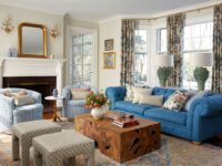 Living room with dusty blue walls, white furniture, and gold accents creating a soft, elegant home decor style