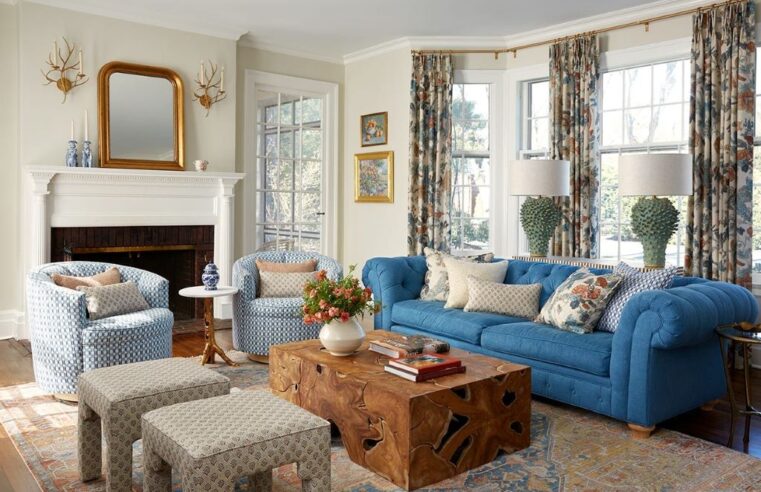 Living room with dusty blue walls, white furniture, and gold accents creating a soft, elegant home decor style