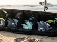 Surfboard fin holder bag with multiple padded compartments for travel