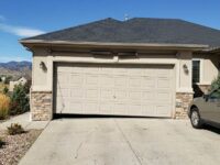 Uneven garage door leaning to one side outside a Denver