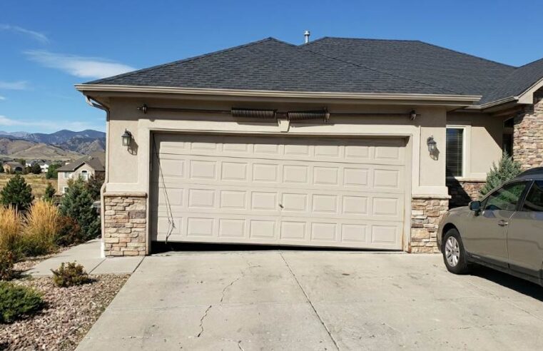 Uneven garage door leaning to one side outside a Denver