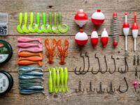 An affordable fishing rod and open tackle box resting on a wooden dock.
