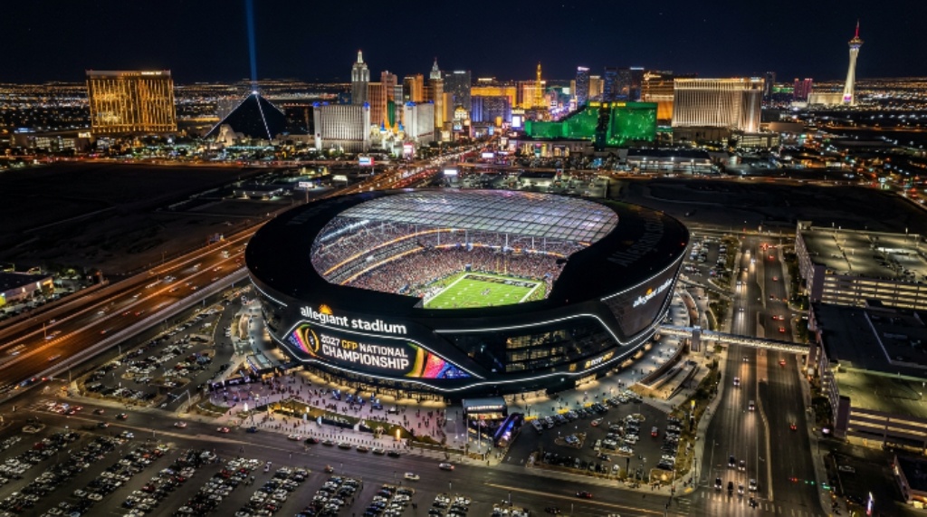 Aerial view of Allegiant Stadium in Las Vegas, Nevada, lit up for the 2027 CFP National Championship on January 25, 2027, with the Las Vegas Strip visible in the background