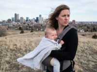 Infant protected in stroller during windy hillside walk