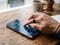 Man checking fitness tracking ring data on smartphone screen.