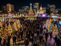 Thousands of visitors walking through Plaza de Cesar Chavez in downtown San Jose at night, surrounded by hundreds of illuminated decorated Christmas trees at Christmas in the Park 2026